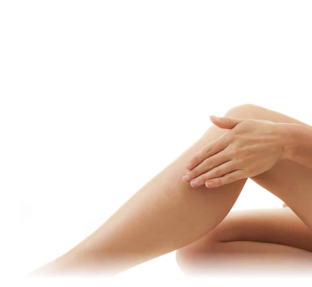 Das Bein einer Frau mit der Hand darauf wird einer Besenreiser entfernen-Behandlung unterzogen.